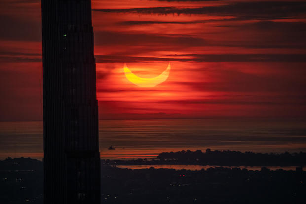 The sun rises over New York City during a solar eclipse on June 10, 2021 as seen from The Edge observatory deck at The Hudson Yards. 