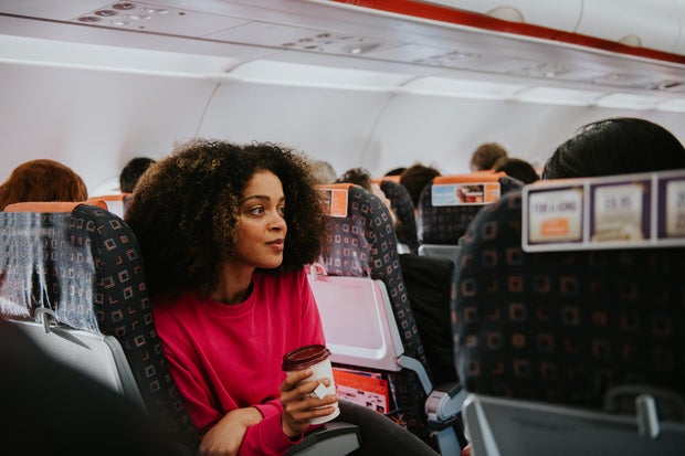 A young woman looks pensive on a plane