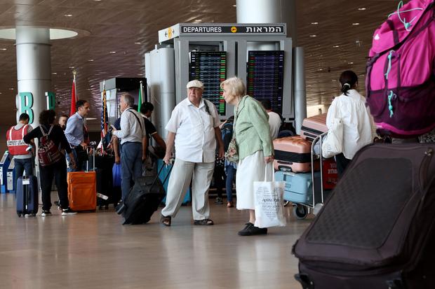 Travelers arrive to check-in at Ben Gurion International Airport near Tel Aviv on October 14, 2023. 