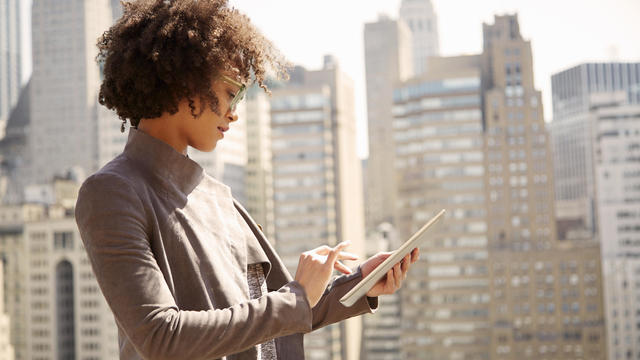 Woman on rooftop holding a tablet computer 