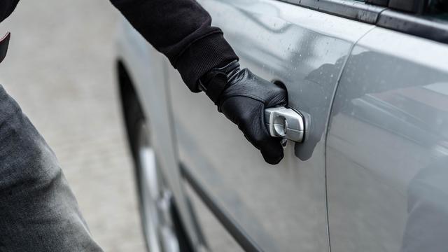 car thief opening a car door 