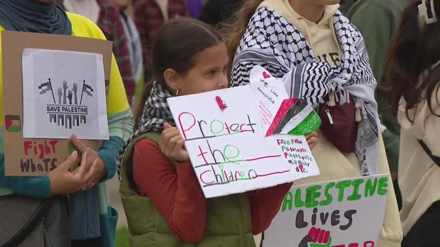 girl holding sign that says "protect the children" 