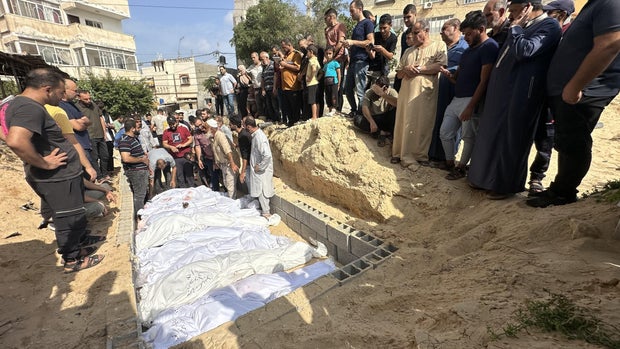 Bodies of Palestinians killed amid ongoing Israeli airstrikes on the Gaza Strip are buried in a mass grave at a cemetery in Deir al-Balah, Gaza, Oct. 23, 2023