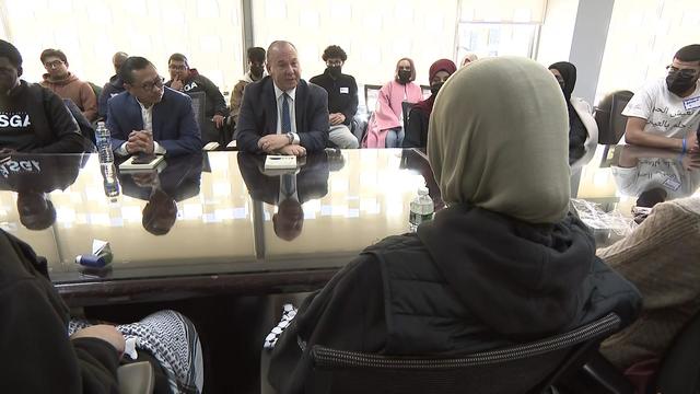 Rabbi Marc Schneier and Imam Shamsi Ali sit at a table in a room with Muslim students. 