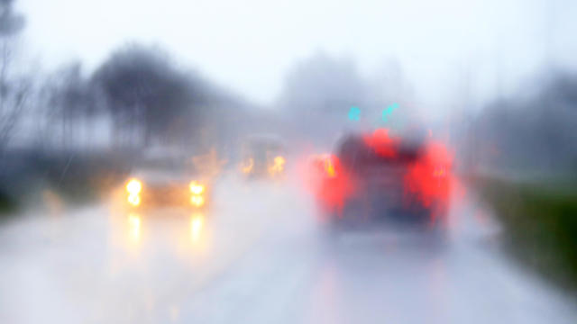Blurry traffic scene through windshield during heavy afternoon rain in Florida 