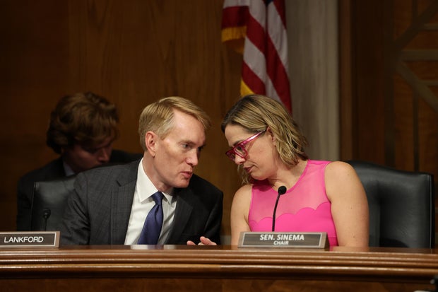 Sen. James Lankford of Oklahoma talks to Sen. Kyrsten Sinema during a Senate hearing on Sept. 6, 2023.