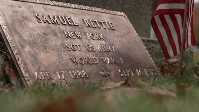 A bronze cemetery plaque reading "Samuel Rettie, New York, Sgt. US Army, World War I." 