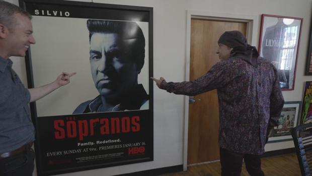 Steven Van Zandt shows Jon Wertheim a "Sopranos" poster 
