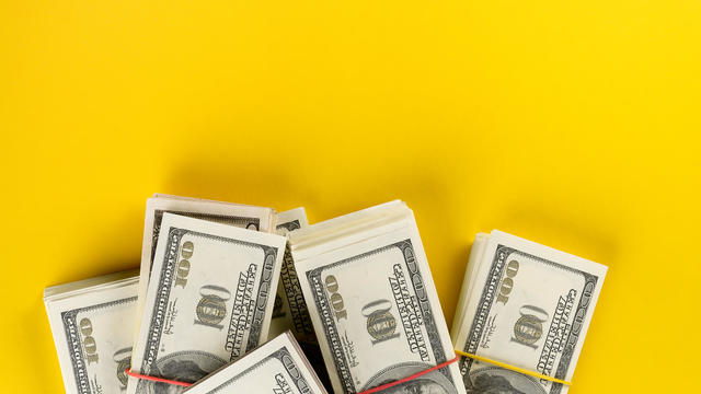 US dollars American Bills in Bundles On a Bright Yellow background. 