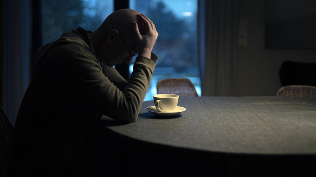 Man sitting alone at his kitchen table 