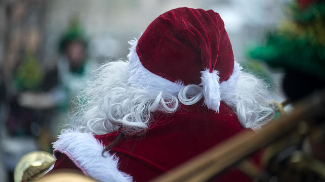 man wearing a santa claus costume in the street 