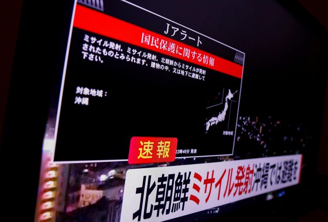 A TV screen displays a warning message after the Japanese government issued an emergency warning for residents of the southern prefecture of Okinawa, saying a missile had been launched from North Korea and that residents should take cover indoors, in Toky