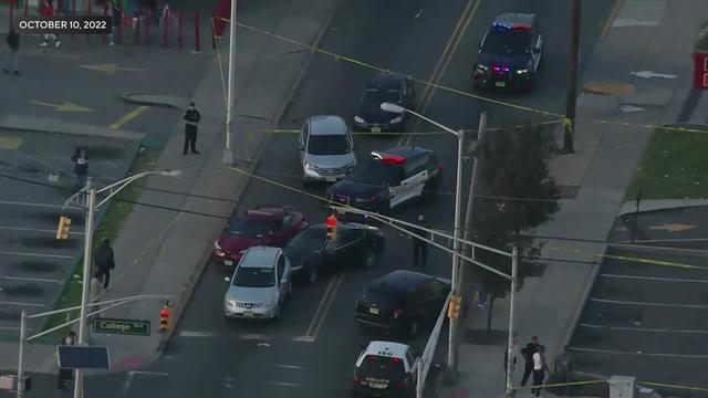 An aerial view of several vehicles and two Newark police vehicles in the middle of a road. 