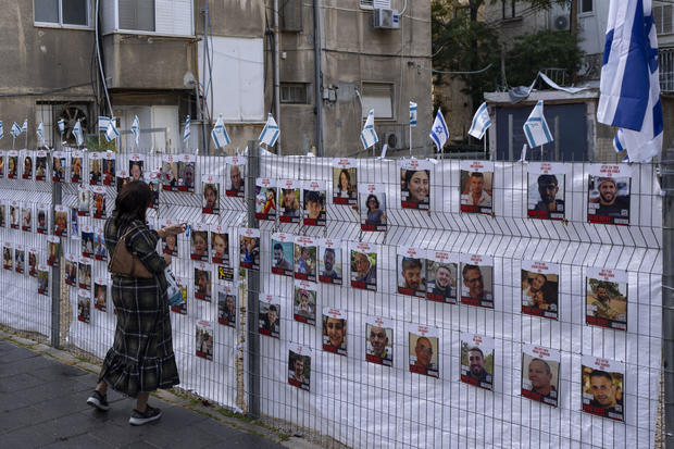 A woman looks at photographs of hostages who were abducted during the Oct. 7 Hamas attack on Israel, 