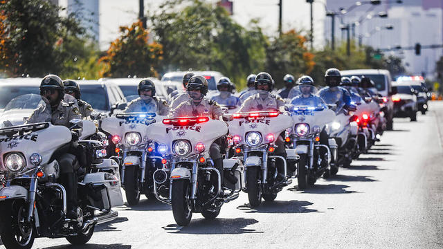 A police procession for a slain Nevada Highway Patrol trooper moves toward the coroner's office in Las Vegas, Nov. 30, 2023. 