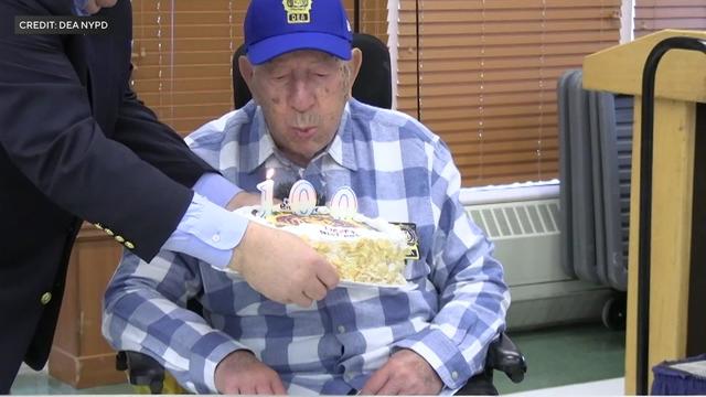 Frank Agoglia blows out candles on a birthday cake. 