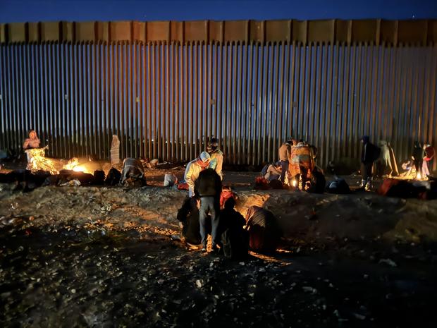 Migrants huddle around fires for warmth along the U.S.-Mexico border near Lukeville, Arizona, on Thursday, Dec. 7, 2023. 