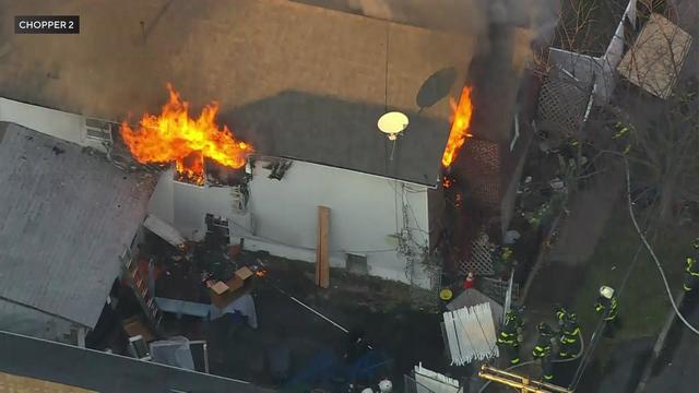 Flames can be seen pouring from the top floor of a Staten Island home. 