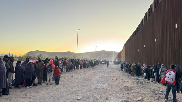Migrants wait along the U.S.-Mexico border in Lukeville, Arizona. 