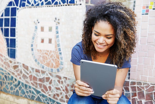 Woman with tablet, mosaic wall. 