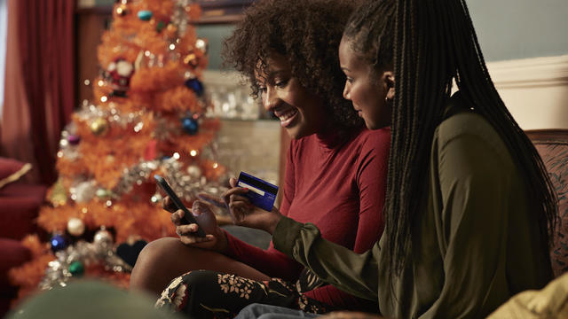 Young women ordering Christmas gifts online with creditcard 