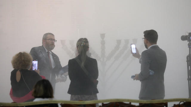 Far-right Polish lawmaker Grzegorz Braun from Konfederacja party stands after using a fire extinguisher to put out Hanukkah candles at the parliament in Warsaw 