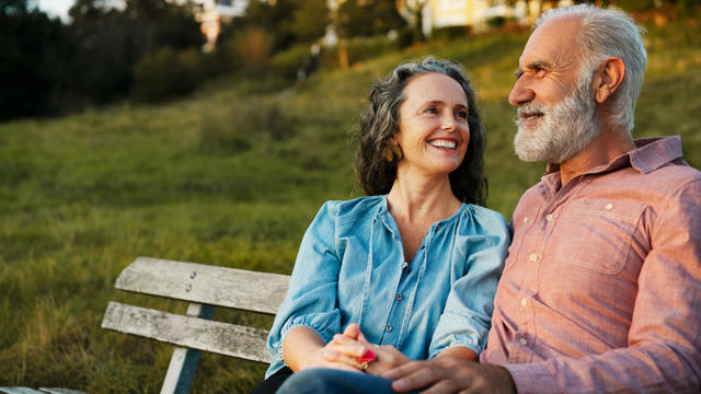 Man and woman on bench, smiling 