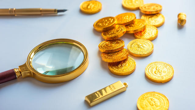 Magnifying glass and gold coins 