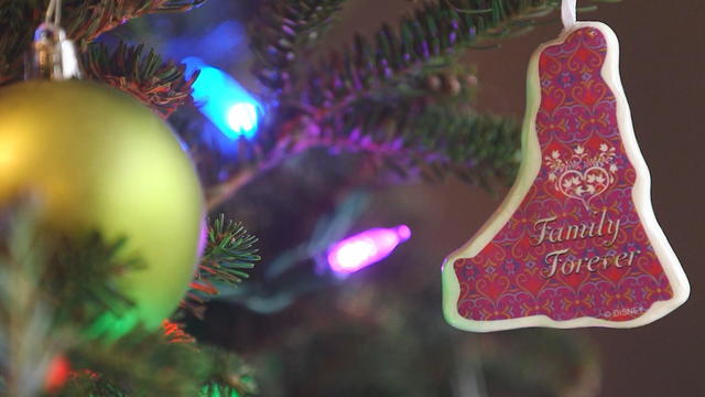 An image of a Christmas tree, zoomed in on an ornament that says family forever 
