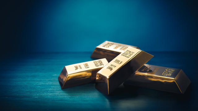 Pile of gold bars or ingots on a dark background 