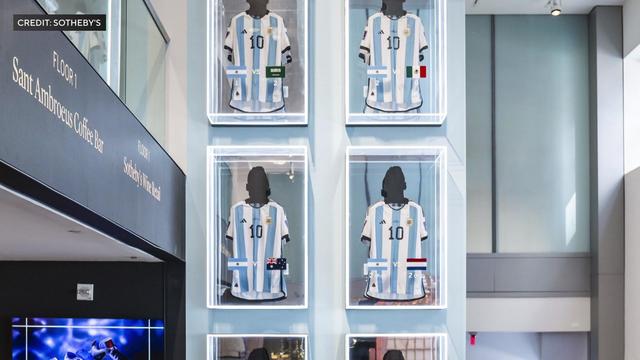Six Lionel Messi jerseys on display behind glass. 