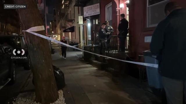 Crime scene tape blocks off a sidewalk on the Upper East Side at night. 