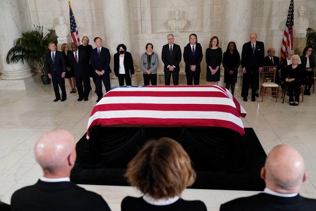 Supreme Court justices stand as the flag-draped casket of retired Justice Sandra Day O'Connor arrives at the Supreme Court on Dec. 18, 2023.