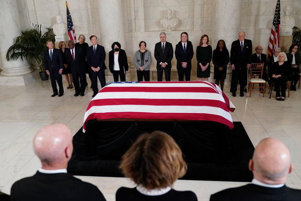 Supreme Court justices stand as the flag-draped casket of retired Justice Sandra Day O'Connor arrives at the Supreme Court on Dec. 18, 2023. 