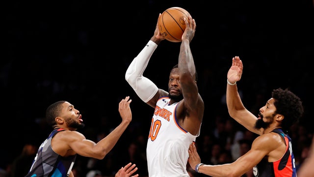 Julius Randle #30 of the New York Knicks looks to pass as Mikal Bridges #1 and Spencer Dinwiddie #26 of the Brooklyn Nets defend during the second half at Barclays Center on December 20, 2023 in the Brooklyn borough of New York City.