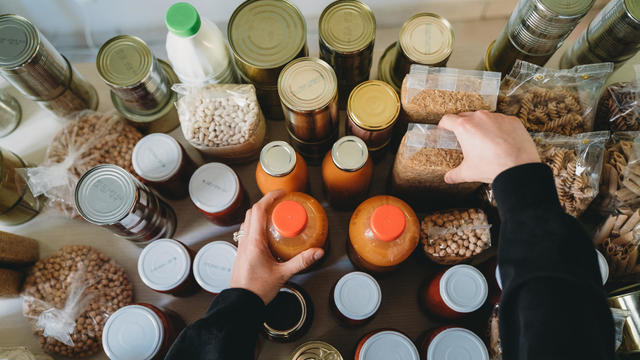 Woman is rearranging the nonperishable food at the food bank 