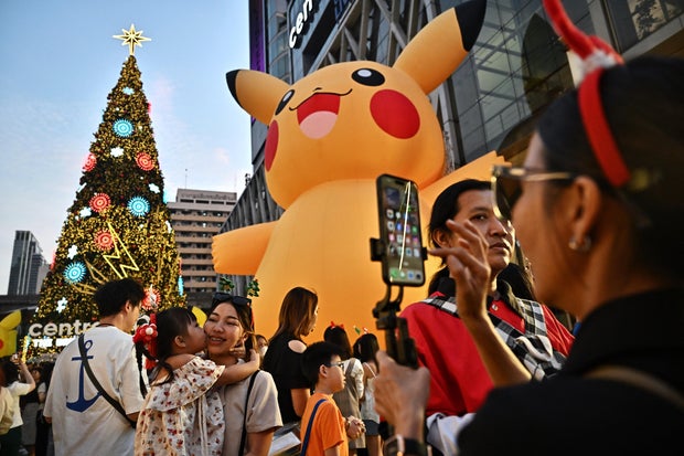 People take pictures and gather around a Pokemon-themed Christmas display in front of the Central World shopping mall in Bangkok, Thailand, on Dec. 25, 2023