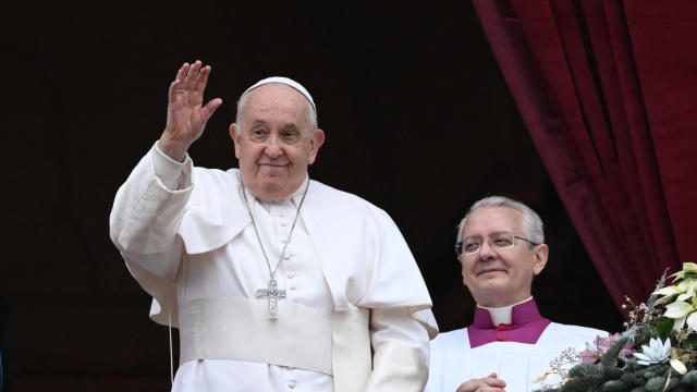 Pope Francis waves from the balcony of St. Peter's basilica on Christmas 
