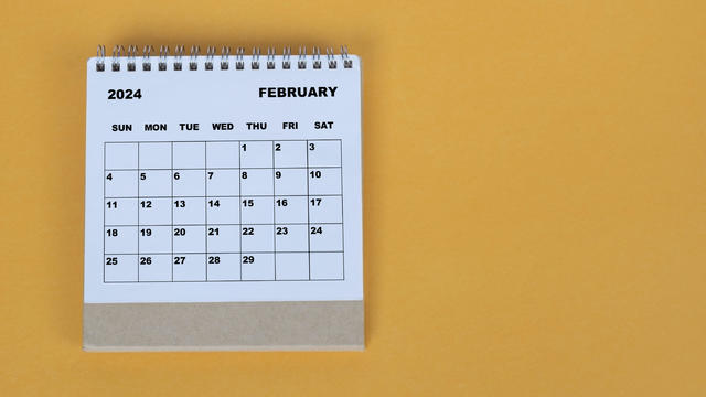 February 2024 desk calendar on yellow background. 