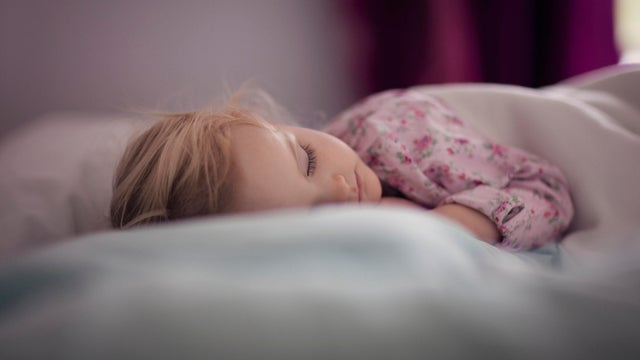 Mixed race baby girl sleeping on bed