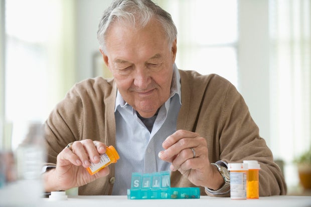 Elderly man taking daily medicine