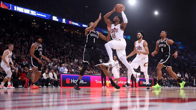 Donovan Mitchell of Cleveland Cavaliers scores against Mikal Bridges and Dennis Smith Jr of Brooklyn Nets during the NBA match between Brooklyn Nets and Cleveland Cavaliers at The Accor Arena on January 11, 2024 in Paris, France. 