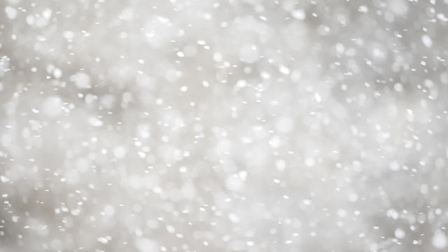 Full frame snowstorm, looking at the sky with gray clouds. 
