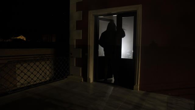 The silhouette of a human in front of a window at night. Scary scene halloween concept of blurred silhouette of maniac. 