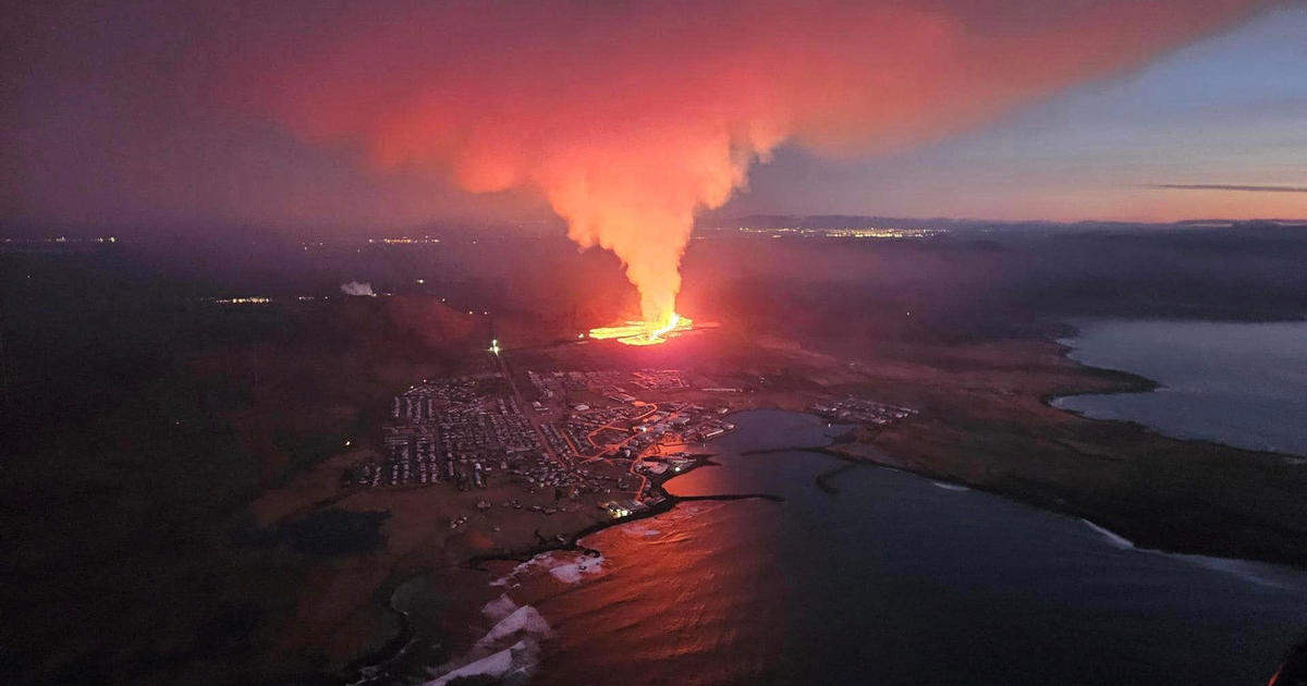 Um vulcão entra em erupção na Islândia, expelindo lava em direção a uma cidade perto do principal aeroporto do país