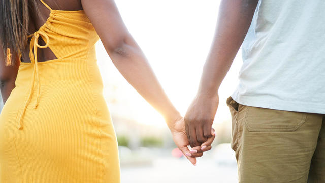 Close-up photo of unrecognizable black couple holding hands. 