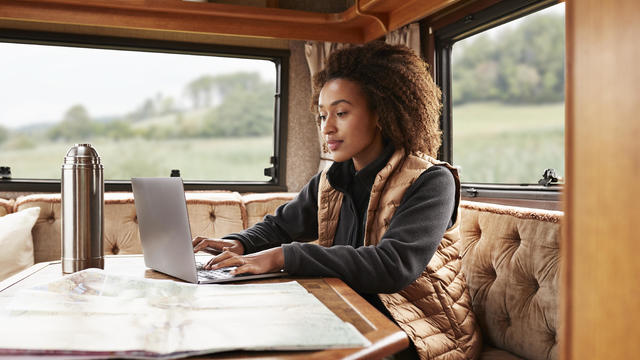 Woman using laptop in camper van 