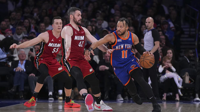 Jalen Brunson #11 of the New York Knicks dribbles the ball against Duncan Robinson #55 and Kevin Love #42 of the Miami Heat in the first half at Madison Square Garden on January 27, 2024 in New York City. 