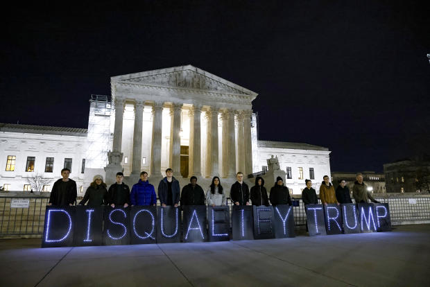 MoveOn members hold signs that read "Disqualify Trump" during a rally outside the Supreme Court on Feb. 1, 2024, in Washington, D.C. 
