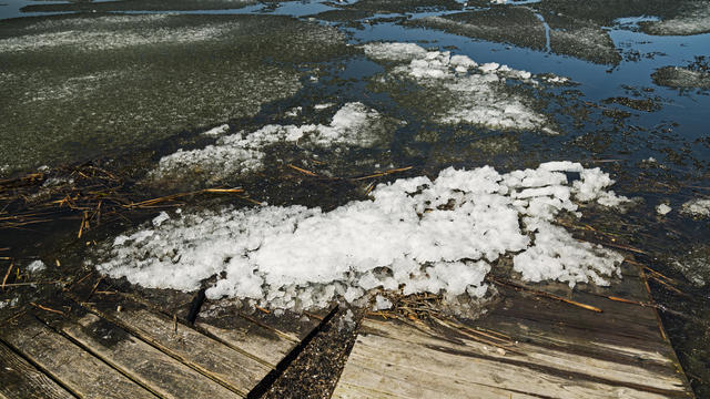 Damaged Wood Boardwalk in Melting Lake Ice Water 